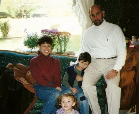 Family of four sitting on antique couches