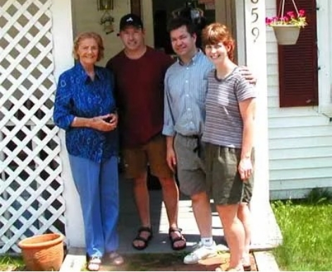 Family of four standing on front porch