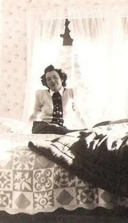 Blurry black and white photo of a woman sitting on a bed