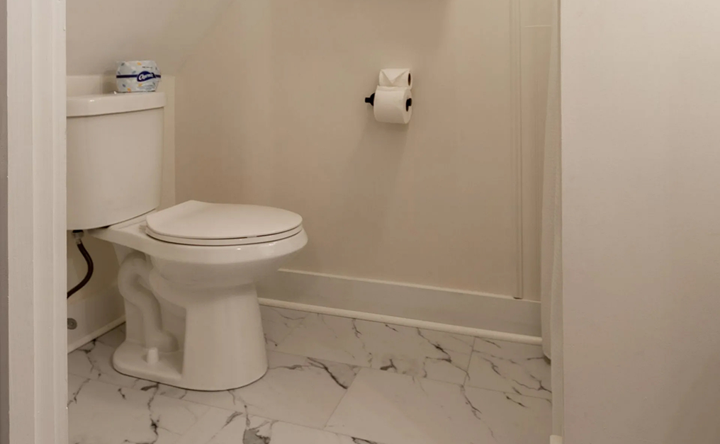 Toilet in bathroom with marble flooring