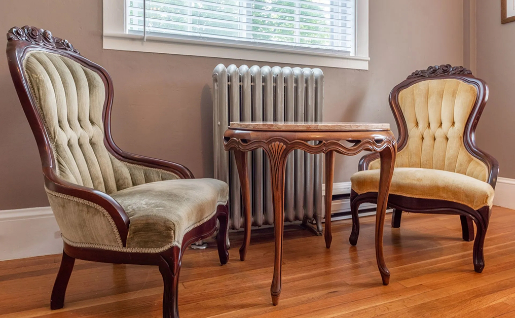 Close up of small antique table and two antique chairs