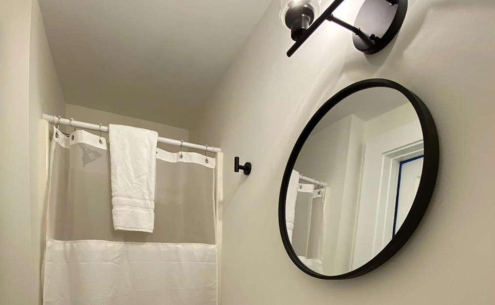 Circular mirror on wall next to walk in shower