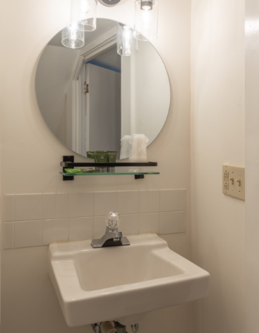 Circular mirror above a sink