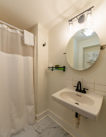 Circular mirror above sink in bathroom with pale yellow walls