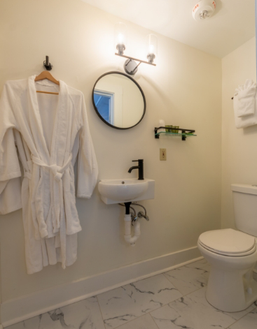 White bathrobe hanging on wall in bathroom with pale yellow walls